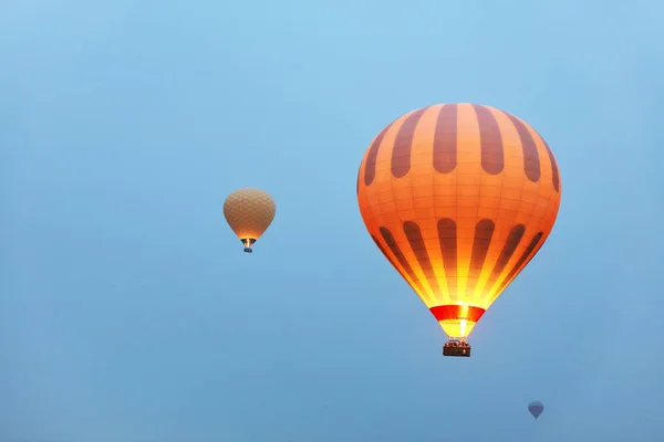 Montgolfières à air chaud avec lumière de feu volant dans le ciel bleu, voyage — Photo