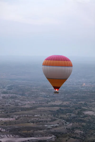 Πολύχρωμο αερόστατο πετά σε ομιχλώδη ουρανό πάνω από τα πεδία — Φωτογραφία Αρχείου