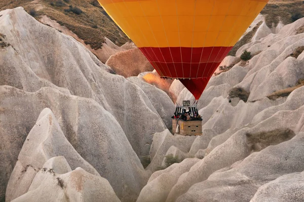 Personnes voyageant dans le panier de montgolfière, volant au-dessus des rochers — Photo