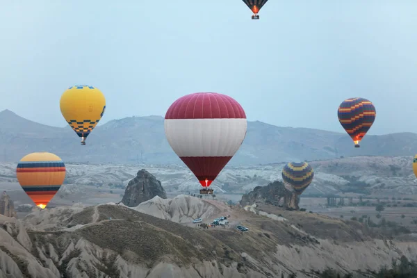 Globos coloridos del aire caliente que vuelan en cielo encima del valle de la roca —  Fotos de Stock