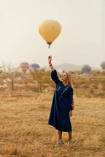हाताने आकाशात हॉट एअर बेलून पोहोचण्याचा प्रयत्न करणारी सुंदर महिला — स्टॉक फोटो, इमेज
