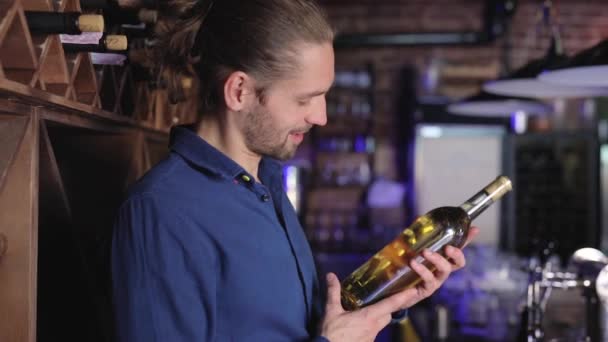 Bel homme tenant bouteille de vin à la cave à vin — Video