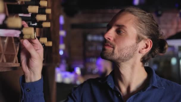 Víno Restaurant. Pohledný muž volba láhev vína na polici — Stock video