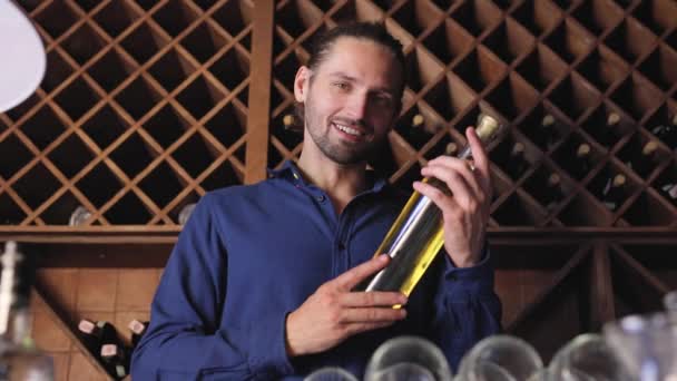 Sorrindo homem com garrafa de vinho em adega no restaurante adega — Vídeo de Stock