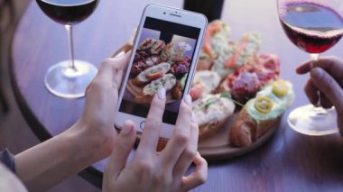 Yiyecek ve içecek fotoğraf. Telefonun ekranında fotoğraflara bakarken kadın