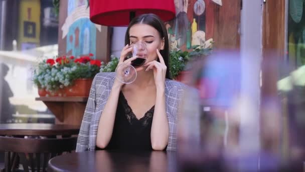 Hermosa mujer bebiendo vino de vidrio en el restaurante — Vídeos de Stock