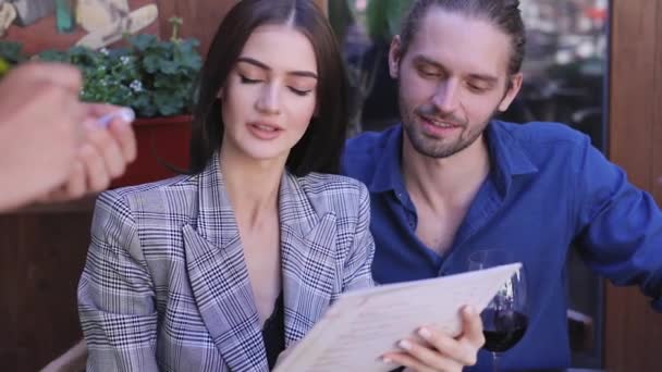 Couple au restaurant. Les gens avec menu rendant l'ordre au café — Video