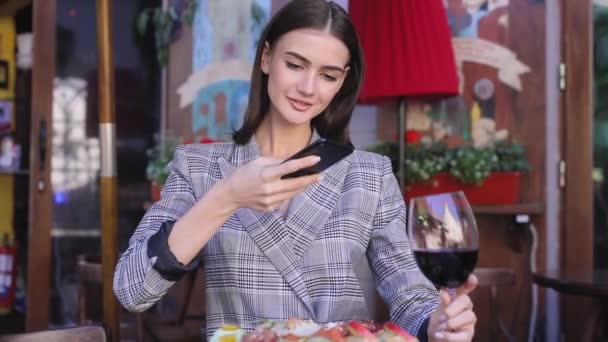 레스토랑에서 휴대 전화에 음식 사진을 찍고 아름 다운 여자 — 비디오