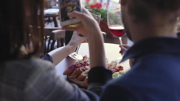 Женщина крупным планом фотографирует по телефону еду в ресторане — стоковое видео