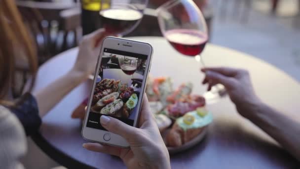 特写镜头的女人在餐厅里拍摄食物和葡萄酒的照片. — 图库视频影像