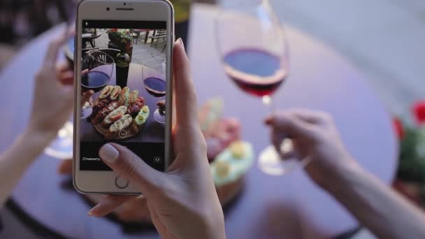 Närbild kvinna tar bilder av mat och vin i restaurang. — Stockvideo