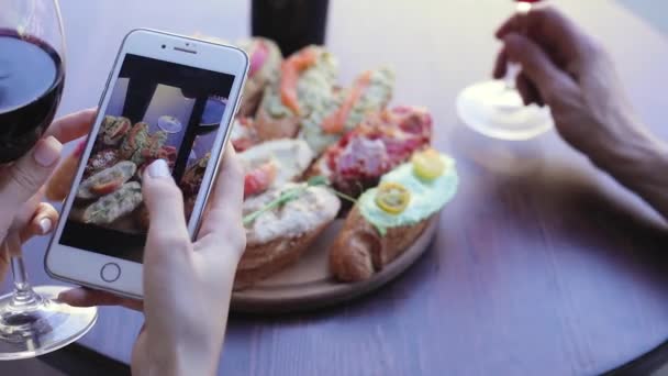 Jedzenie i napoje zdjęcie. Kobieta, patrząc na zdjęcia na ekranie telefonu — Wideo stockowe