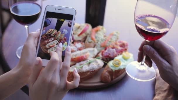 Фото еды и напитков. Женщина смотрит на фотографии на экране телефона — стоковое видео