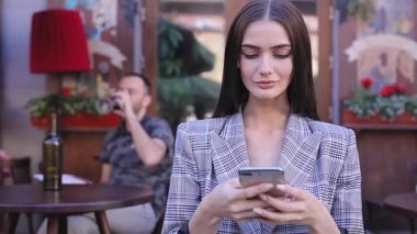 Güzel kadın cep telefonunuzun açık Cafe