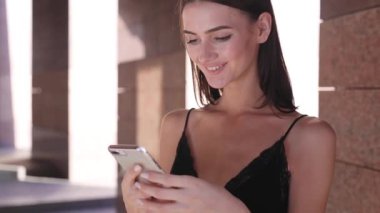 Cep telefonu açık havada kullanan güzel gülümseyen kadın