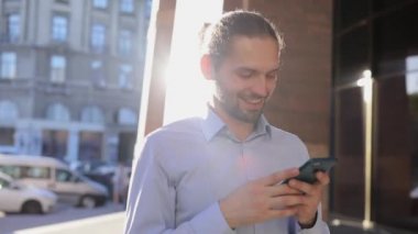 Cep telefonu açık havada Street güneşli günde kullanarak iş adamı