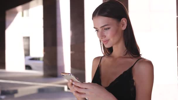 Όμορφη χαμογελαστή γυναίκα χρήση κινητού σε εξωτερικούς χώρους — Αρχείο Βίντεο