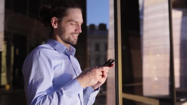 Άνθρωπος των επιχειρήσεων χρησιμοποιώντας κινητό τηλέφωνο κοντά σε κτίριο γραφείων — Αρχείο Βίντεο