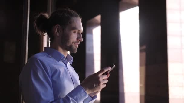 Άνθρωπος των επιχειρήσεων χρησιμοποιώντας κινητό τηλέφωνο κοντά σε κτίριο γραφείων — Αρχείο Βίντεο