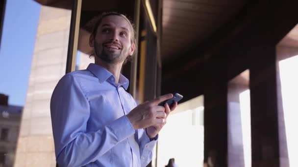Obchodní muž používající mobilní telefon poblíž kancelářská budova — Stock video