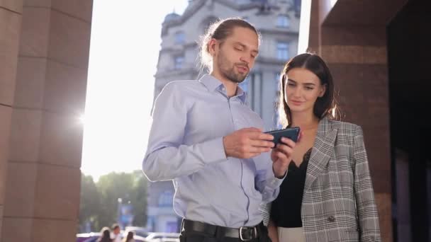 Lidé, technologie. Obchodní muž a žena pomocí telefon venku — Stock video