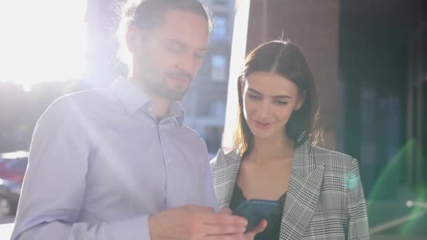 Люди, технології. Бізнес чоловік і жінка використовуючи телефон на відкритому повітрі — стокове відео