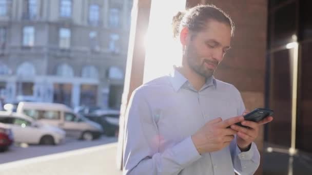 Zakenman gebruik mobiele telefoon buiten op zonnige dag op straat — Stockvideo