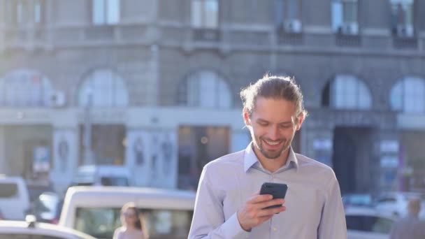 Hombre de negocios usando el teléfono móvil en la calle en el día soleado — Vídeos de Stock