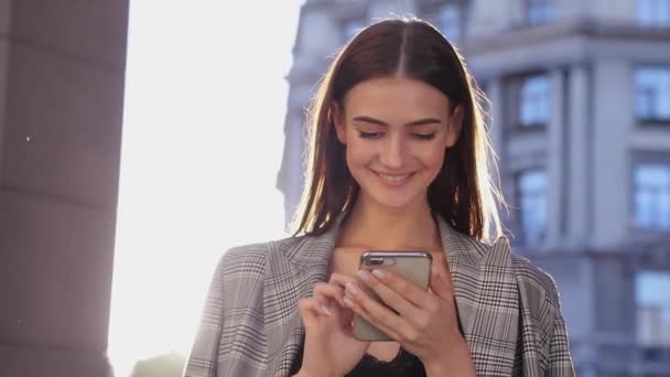 Mooie zakenvrouw gebruik mobiele telefoon buiten op een zonnige dag — Stockvideo