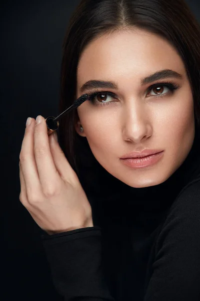 Make-up cosmetica. Vrouw met schoonheid gezicht toepassing van zwarte Mascara — Stockfoto