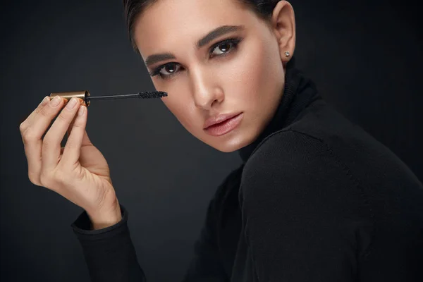 Make-up cosmetica. Vrouw met schoonheid gezicht toepassing van zwarte Mascara — Stockfoto