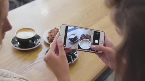 女子手拿食物照片在手机在咖啡馆特写镜头 — 图库视频影像