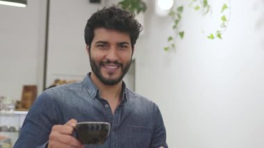 Cafe kahve fincanı adamla gülümseyen portresi. Kupa içki elinde tutan erkek 