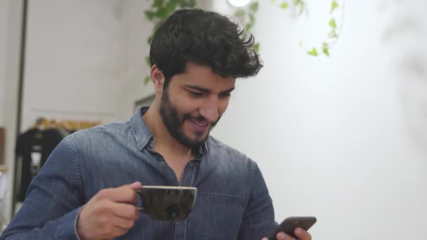 Homem usando telefone celular e beber café no café — Vídeo de Stock