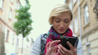 Güzel kadın cep telefonuyla şehir Sokağı'nda. Smartphone açık havada ile gülümseyen kız