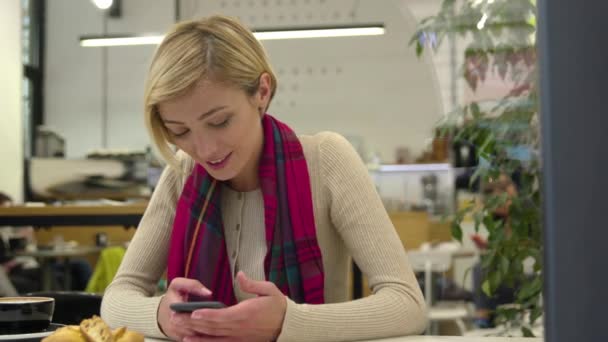 Teknik. Leende kvinna med mobiltelefon i Cafe inomhus — Stockvideo