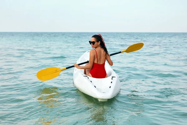 Каякинг. Жінка подорожує в каное на морі Вид ззаду — стокове фото