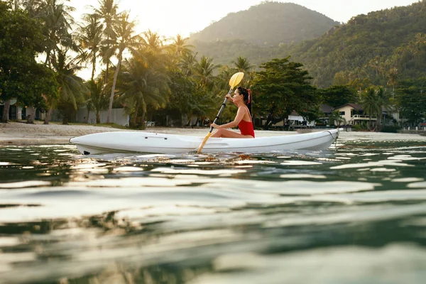 Sommerreisen. Kajakfahrerin im Meerwasser nahe grüner Insel — Stockfoto