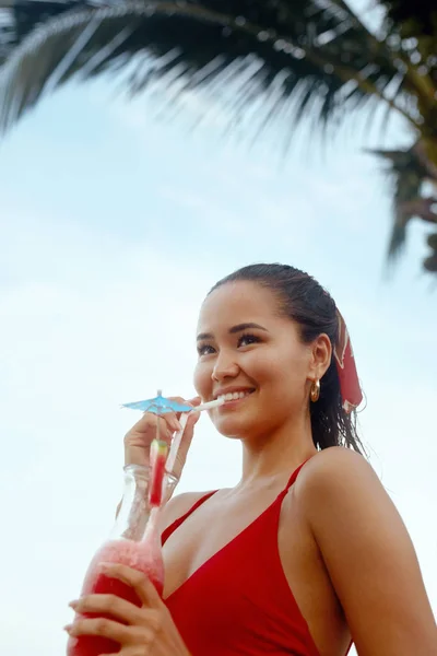 Schöne Frau trinkt exotischen Cocktail am Strand — Stockfoto