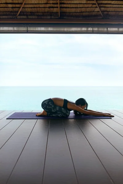Yoga träning. Kvinna i Sport kläder Stretching kropp nära havet — Stockfoto