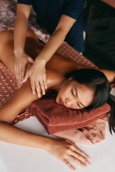 Massagem Tailandesa. Mulher tendo relaxamento massagem nas costas no salão de Spa — Fotografia de Stock