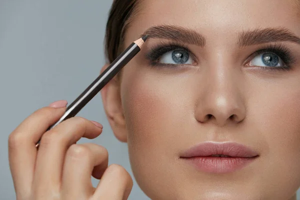 Makijaż kosmetyczny. Kobieta kształtowanie brwi z brwi ołówek zbliżenie — Zdjęcie stockowe