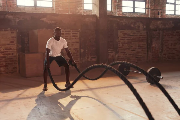 Entraînement de fitness. Homme de sport faisant des exercices de corde de combat au gymnase — Photo