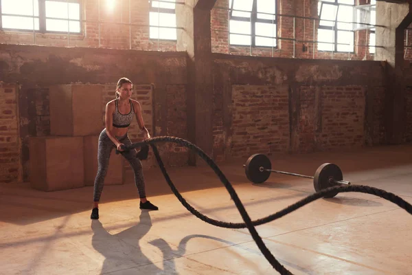 Treino de cordas. Mulher do esporte fazendo exercício de cordas de batalha no ginásio — Fotografia de Stock