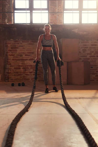Treino de fitness. Mulher do esporte fazendo exercício de corda de batalha no ginásio — Fotografia de Stock