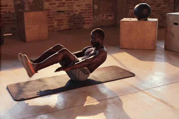 Hombre de deporte haciendo ejercicios abdominales en el gimnasio en interiores. Aptitud — Foto de Stock