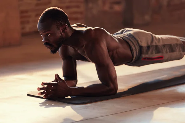 Homem do esporte que faz o exercício da prancha no exercício da aptidão no gym — Fotografia de Stock