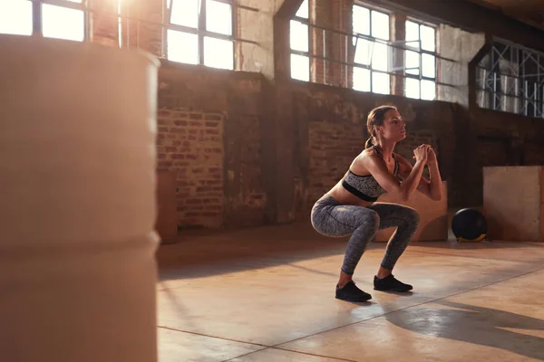 Fitnesz edzés. Sport nő csinál guggoló láb gyakorlat tornaterem — Stock Fotó