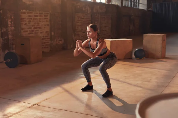 Фитнес-тренировка. Спортивная женщина делает упражнения на ногах в спортзале — стоковое фото