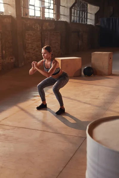 Posilovací cvičení. Sportovní žena dělá squat nohou cvičení v posilovně — Stock fotografie